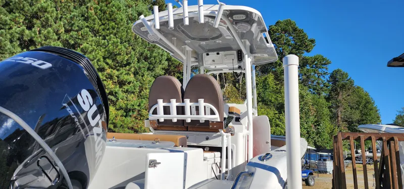 Slide: The Image of 2025 Seapro 222CC boat with Suzuki engine, docked near trees under clear blue sky. - 3