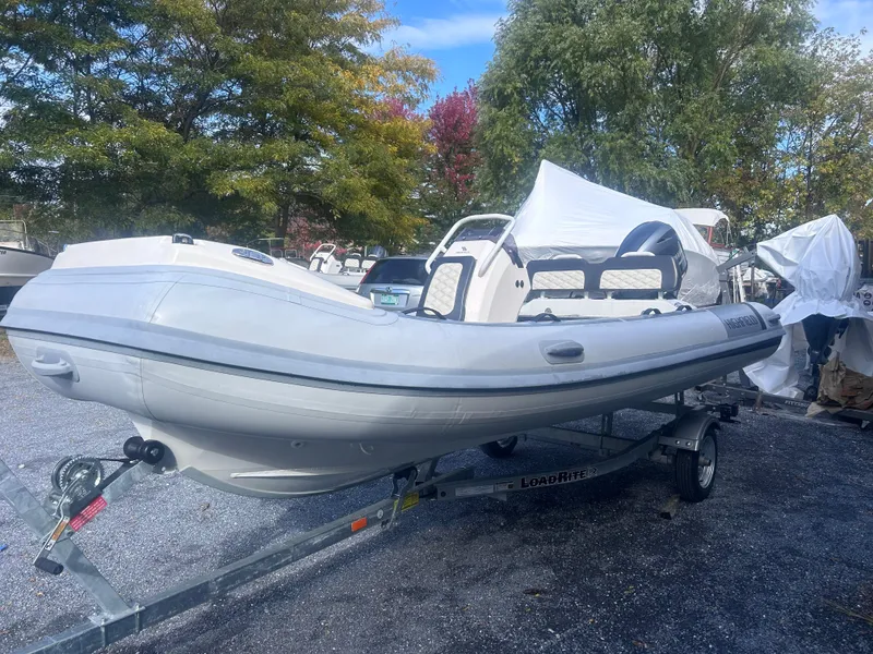 Slide: The Image of 2023 Highfield Sport 460 inflatable boat on trailer, outdoor setting. - 9