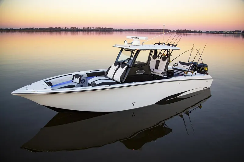 The Image of 2025 Fountain 32 NX boat on calm water at sunset. - 0