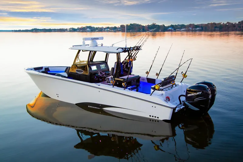 Slide: The Image of 2025 Fountain 32 NX boat on calm water at sunset, equipped with fishing rods. - 2