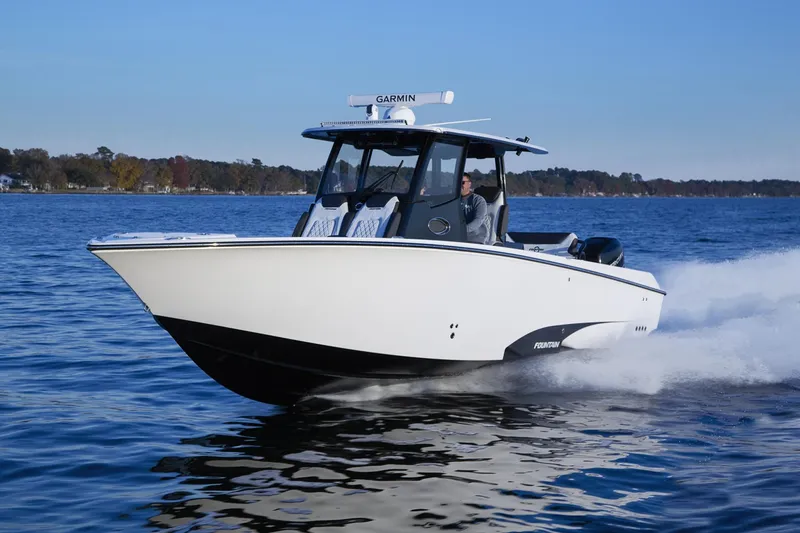 Slide: The Image of 2025 Fountain 32 NX boat cruising on a calm lake. - 3