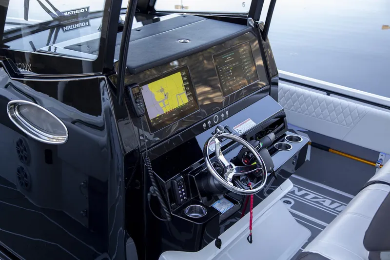 Slide: The Image of 2025 Fountain 32 NX boat dashboard with navigation screens and steering wheel. - 4