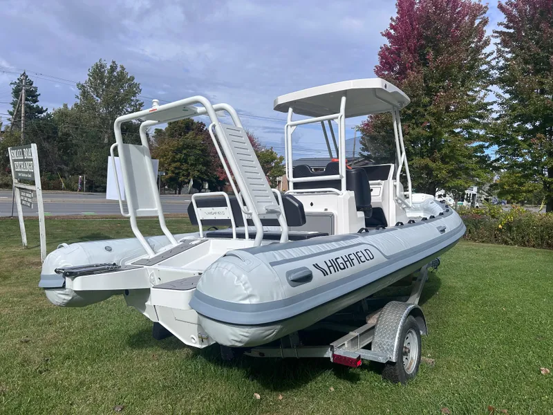 Slide: The Image of 2024 Highfield Sport 660 boat on trailer, displayed outdoors with trees in background. - 6