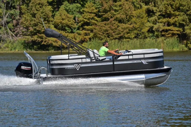 Slide: The Image of 2023 Viaggio DM18U pontoon boat cruising on a lake with lush green trees. - 3