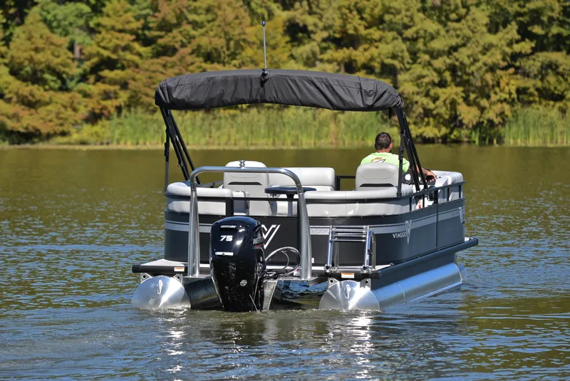 Slide: The Image of 2023 Viaggio DM18U pontoon boat cruising on a serene lake. - 7