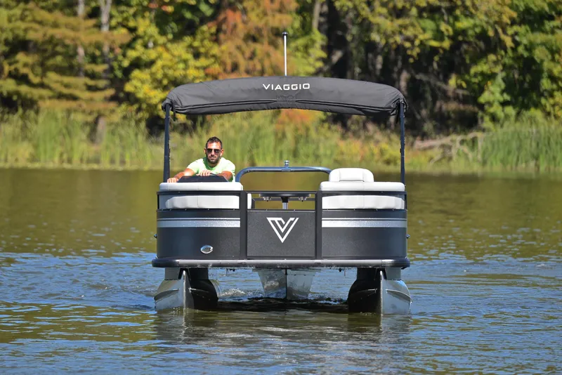 Slide: The Image of 2023 Viaggio DM18U pontoon boat on a lake with lush greenery. - 8