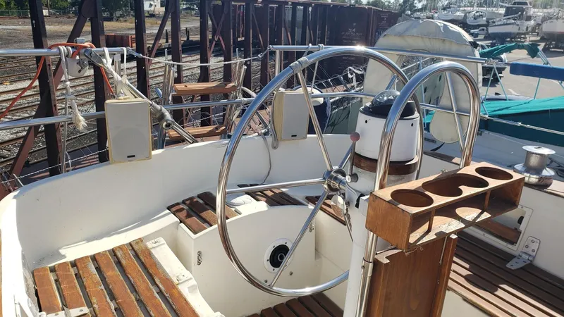 Slide: The Image of 1983 Wauquiez 38 MKI sailboat cockpit with dual steering wheels and wooden deck. - 11