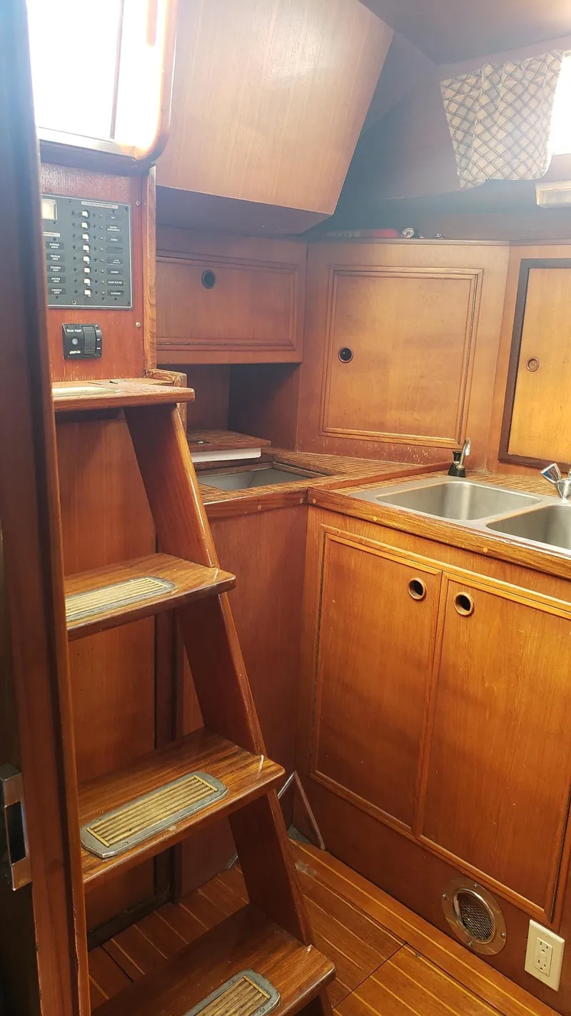 Slide: The Image of 1983 Wauquiez 38 MKI yacht interior with wooden cabinetry and stairs. - 16