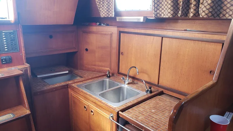 Slide: The Image of 1983 Wauquiez 38 MKI yacht interior kitchen with wooden cabinetry and dual sinks. - 18