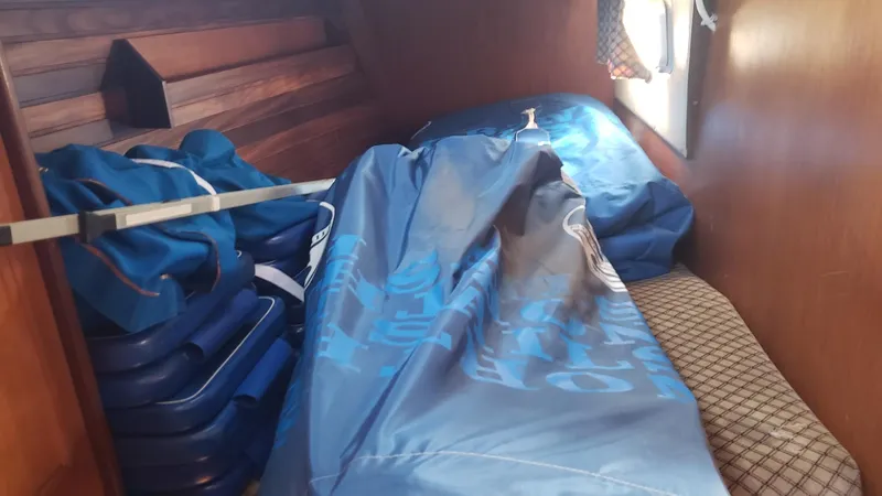 Slide: The Image of Interior cabin of 1983 Wauquiez 38 MKI sailboat with blue bags and cushions. - 27