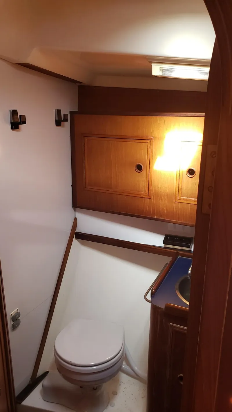 Slide: The Image of 1983 Wauquiez 38 MKI yacht bathroom with wooden cabinets and compact toilet. - 28