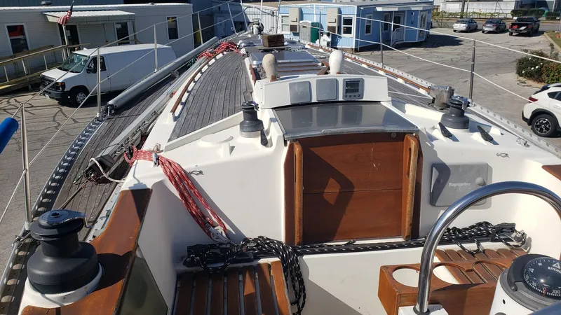 Slide: The Image of 1983 Wauquiez 38 MKI sailboat deck with winches and ropes in a marina setting. - 5