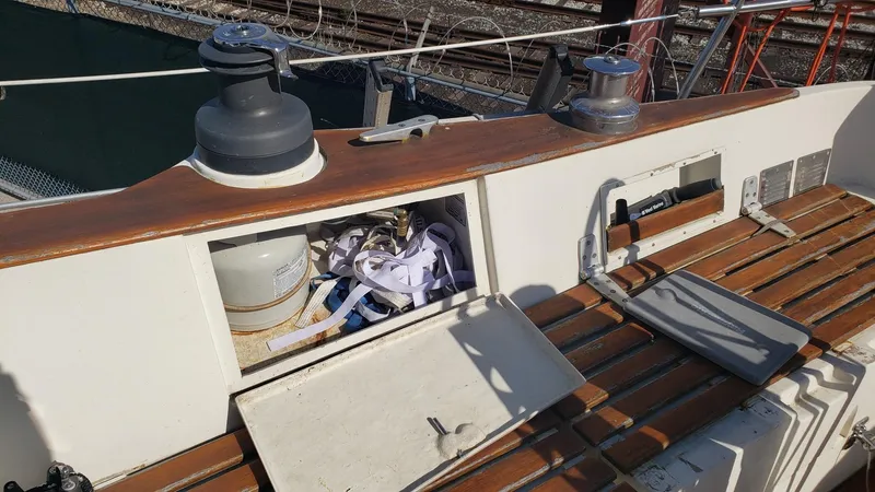 Slide: The Image of 1983 Wauquiez 38 MKI sailboat deck with open storage compartment and winches. - 8