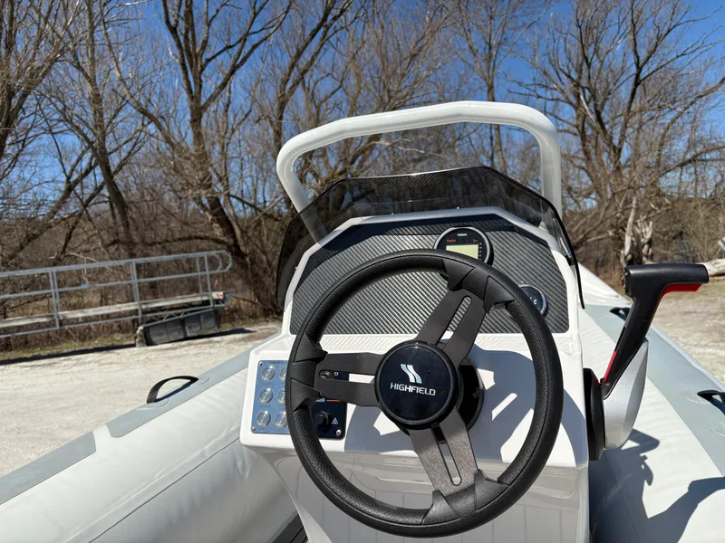Slide: The Image of 2024 Highfield Sport 390 boat steering console with modern design, outdoors. - 11