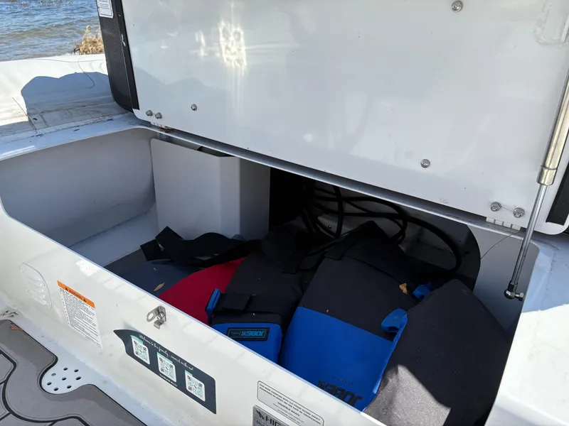 Slide: The Image of Open storage compartment of 2024 Highfield Sport 390 boat with life jackets inside. - 13