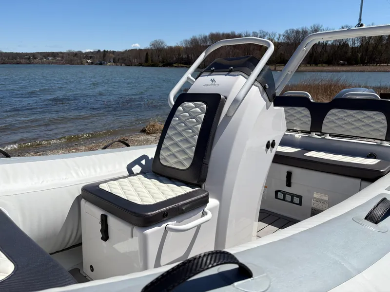 Slide: The Image of 2024 Highfield Sport 390 boat interior with quilted seats by a lake. - 14