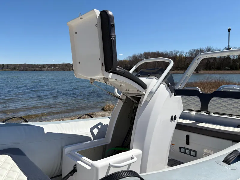 Slide: The Image of 2024 Highfield Sport 390 boat interior with open storage compartment by the water. - 15