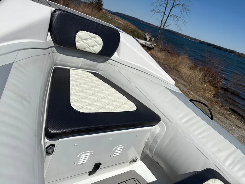 Slide: The Image of 2024 Highfield Sport 390 boat interior with quilted seating by a lake. - 18
