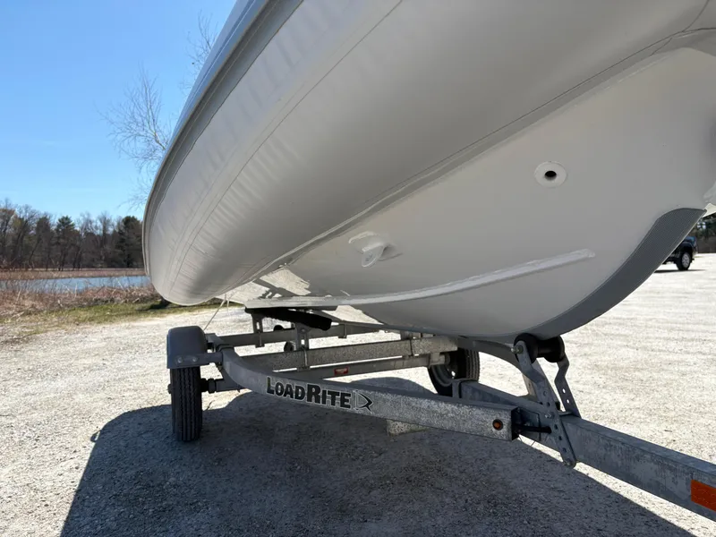 Slide: The Image of 2024 Highfield Sport 390 boat on LoadRite trailer, parked near a lake. - 21