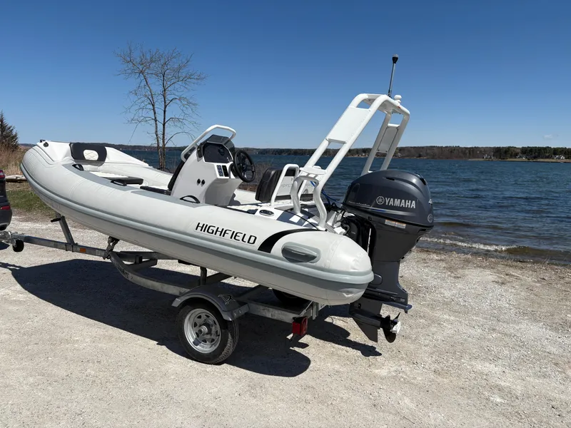 Slide: The Image of 2024 Highfield Sport 390 boat on trailer by the lake, featuring Yamaha outboard motor. - 4