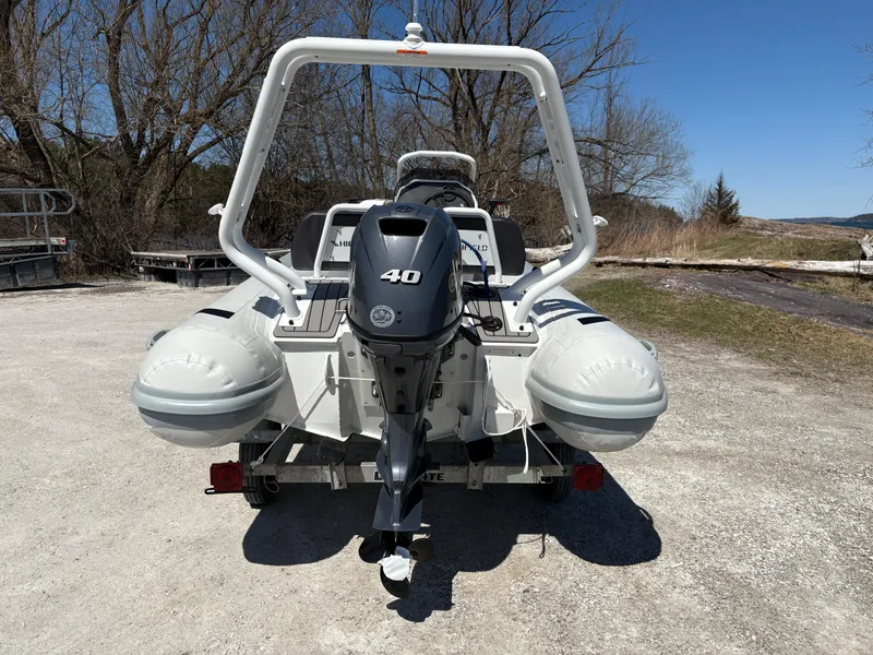 Slide: The Image of 2024 Highfield Sport 390 boat with 40 HP engine, parked on a trailer outdoors. - 6