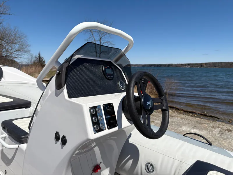 Slide: The Image of 2024 Highfield Sport 390 boat dashboard by a serene lakeside. - 9