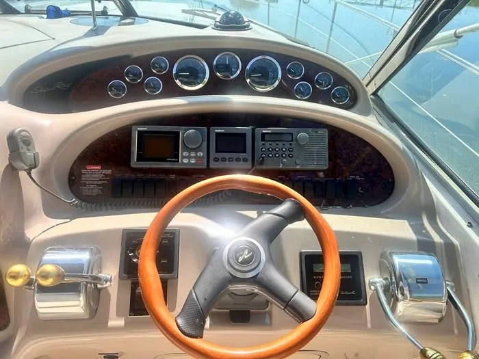 Slide: The Image of Cockpit of 2000 Sea Ray 410 Sundancer with steering wheel and navigation instruments. - 12