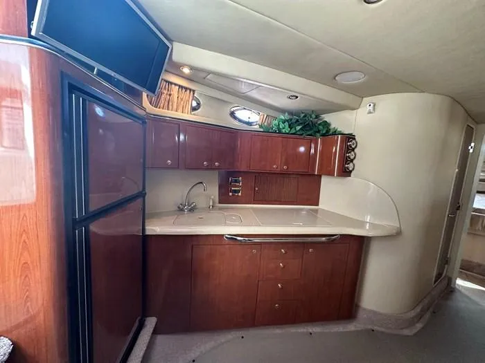 Slide: The Image of Interior of 2000 Sea Ray 410 Sundancer yacht with kitchenette and wood cabinetry. - 16