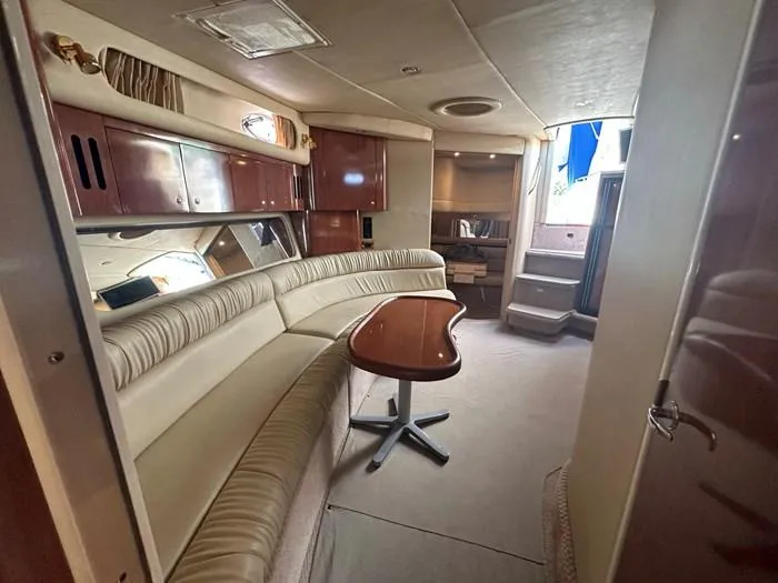 Slide: The Image of Luxurious interior of 2000 Sea Ray 410 Sundancer yacht with plush seating and wooden table. - 19