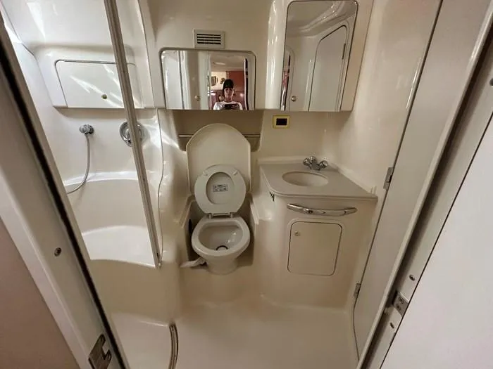 Slide: The Image of Bathroom interior of 2000 Sea Ray 410 Sundancer yacht, featuring toilet, sink, and shower. - 5