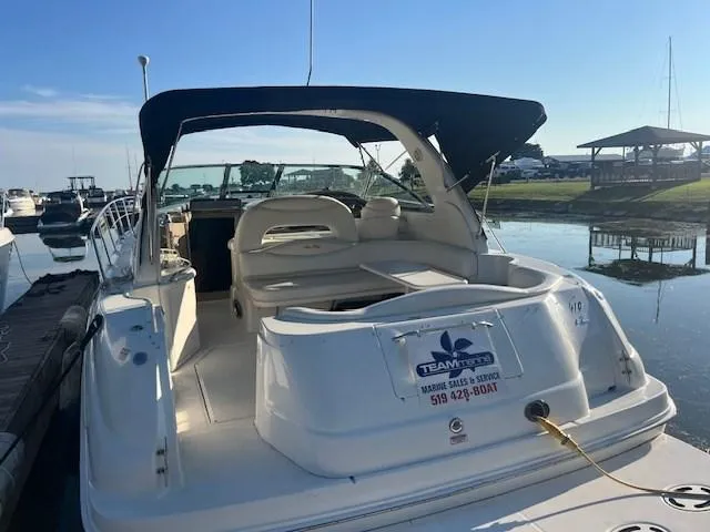 Slide: The Image of 2000 Sea Ray 410 Sundancer docked, featuring spacious seating and canopy. - 8