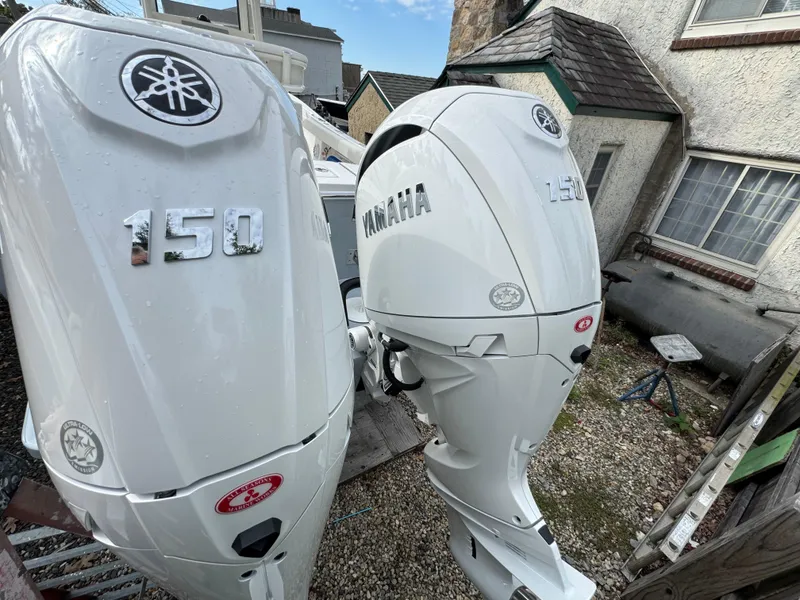 Slide: The Image of Twin Yamaha outboard motors on 2025 Regulator 23 boat, parked outdoors. - 2