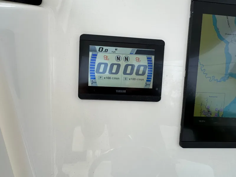 Slide: The Image of 2025 Regulator 23 boat interior with seating and storage, docked under a cloudy sky. - 5