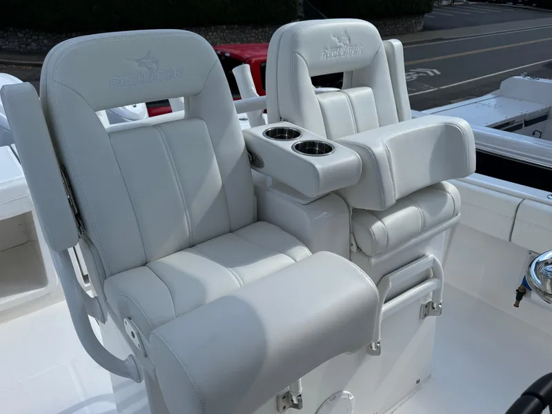 Slide: The Image of 2025 Regulator 28 boat seats with cup holders, featuring white leather upholstery. - 10