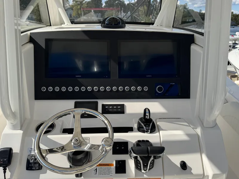 Slide: The Image of 2025 Regulator 28 boat dashboard with dual screens and steering wheel. - 11