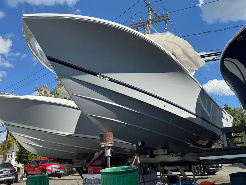 Slide: The Image of 2025 Regulator 28 boat on trailer under clear blue sky. - 2
