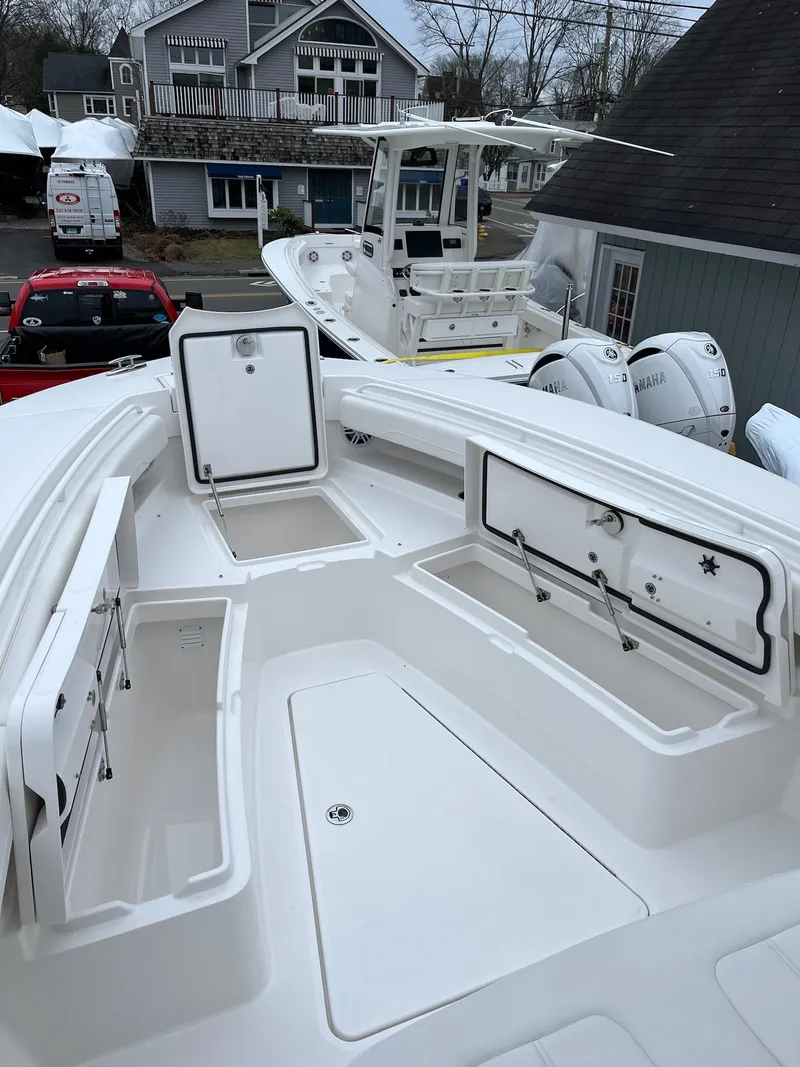 Slide: The Image of 2025 Regulator 28 boat with open storage compartments, docked near buildings. - 20