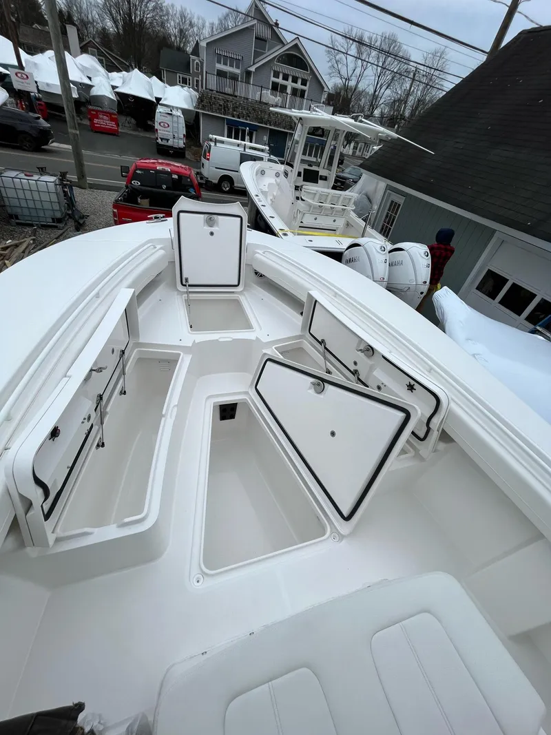 Slide: The Image of 2025 Regulator 28 boat with open storage compartments, docked in a marina. - 21