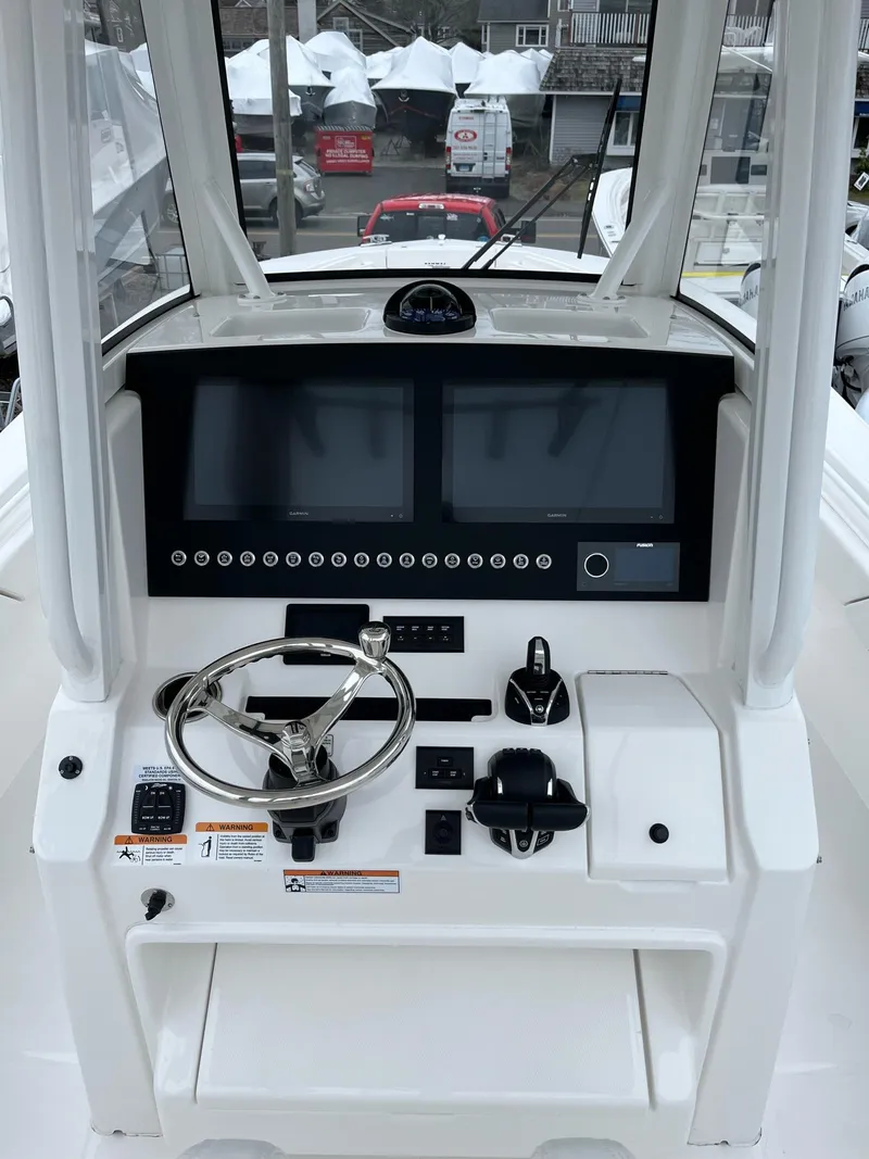 Slide: The Image of 2025 Regulator 28 boat dashboard with dual screens and steering wheel. - 22