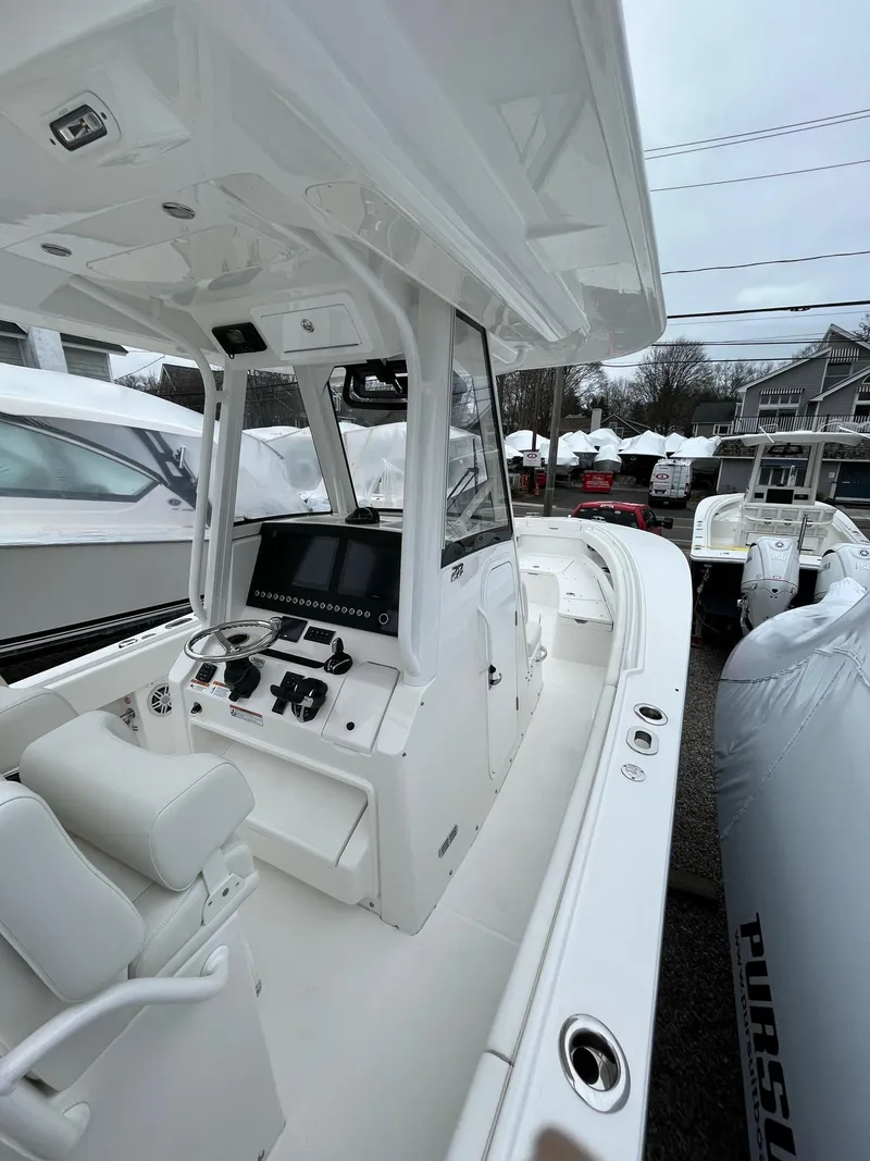 Slide: The Image of 2025 Regulator 28 boat with modern console and seating, docked outdoors. - 24