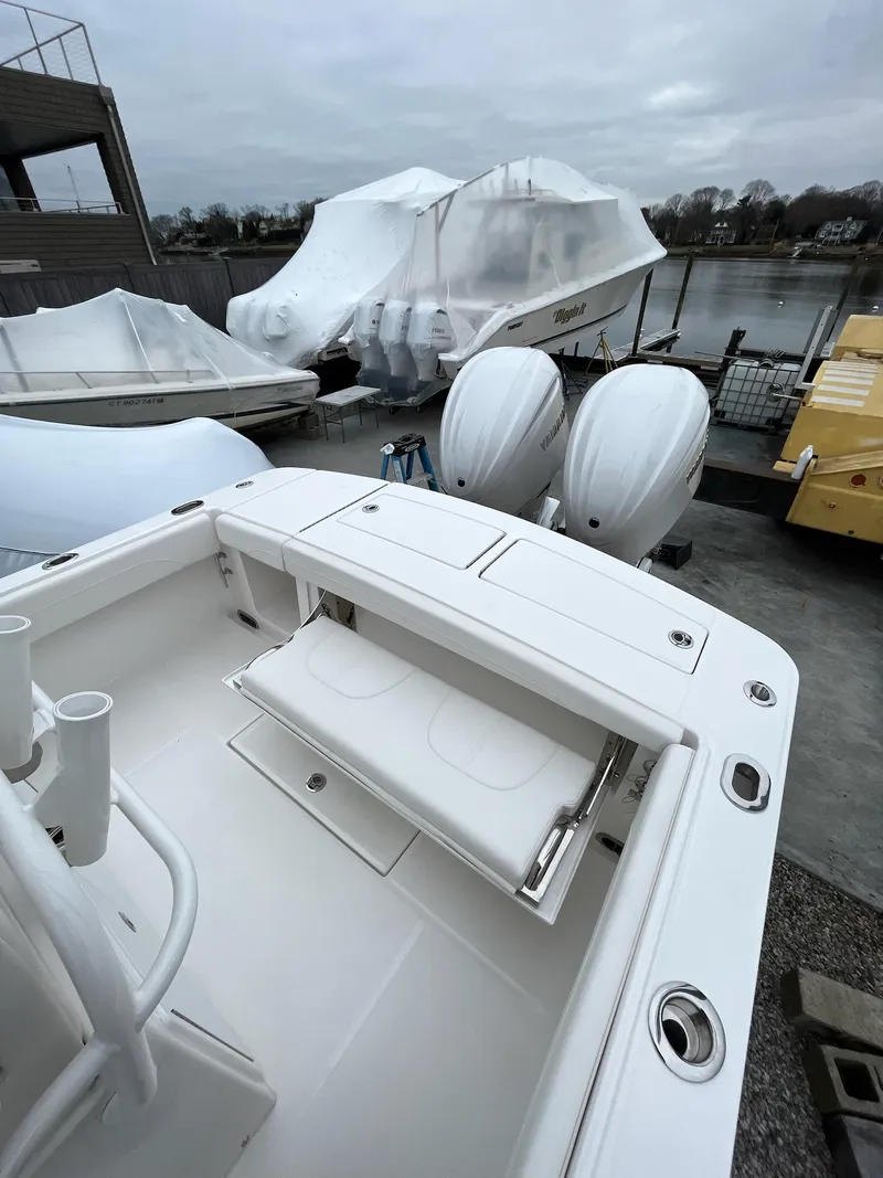 Slide: The Image of 2025 Regulator 28 boat with dual engines, docked near covered vessels. - 26