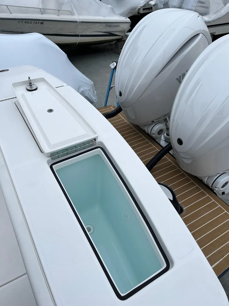 Slide: The Image of 2025 Regulator 28 boat with dual outboard engines and open storage compartment. - 28