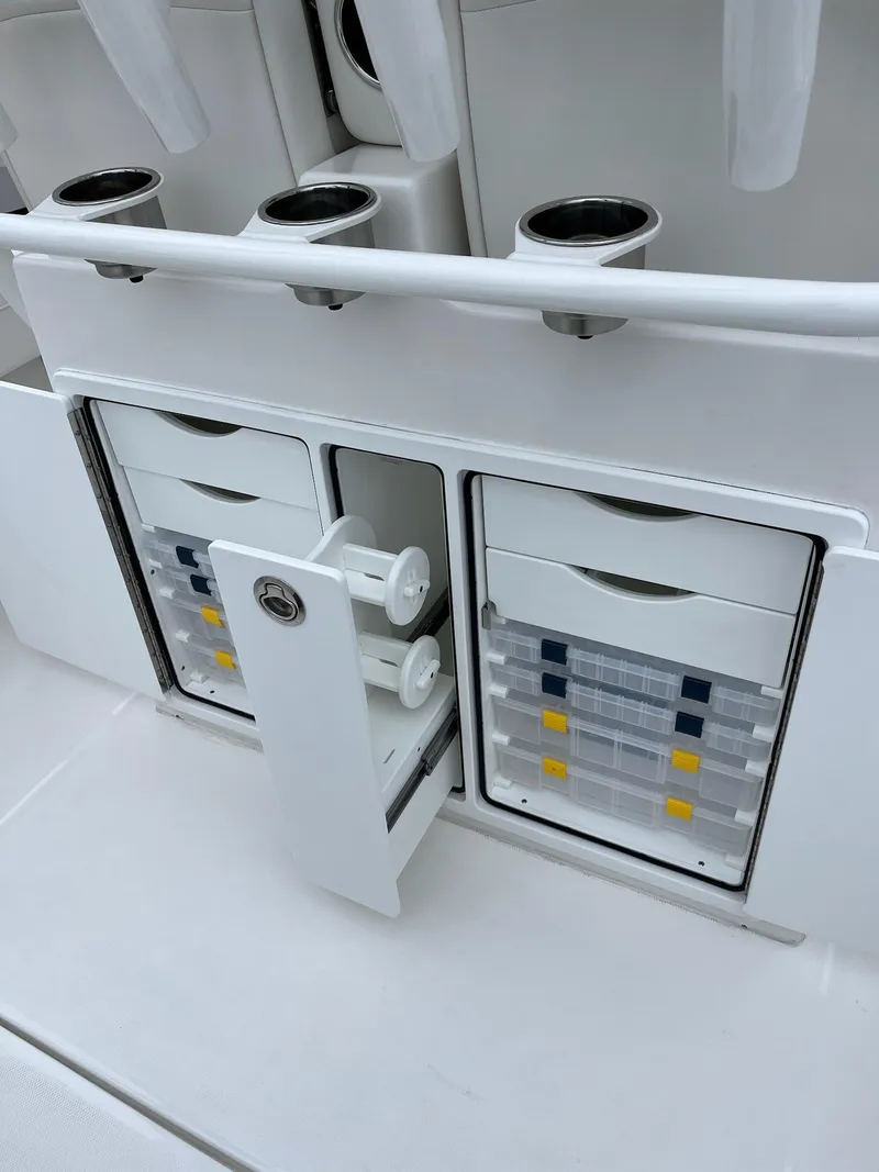 Slide: The Image of 2025 Regulator 28 boat storage compartments with organized tackle boxes and rod holders. - 30