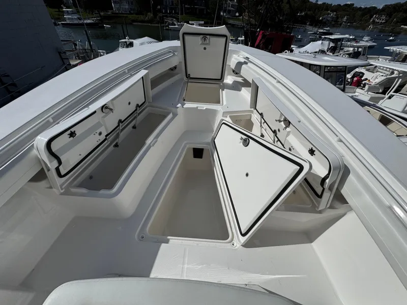 Slide: The Image of 2025 Regulator 28 boat with open storage compartments, docked in a marina. - 4