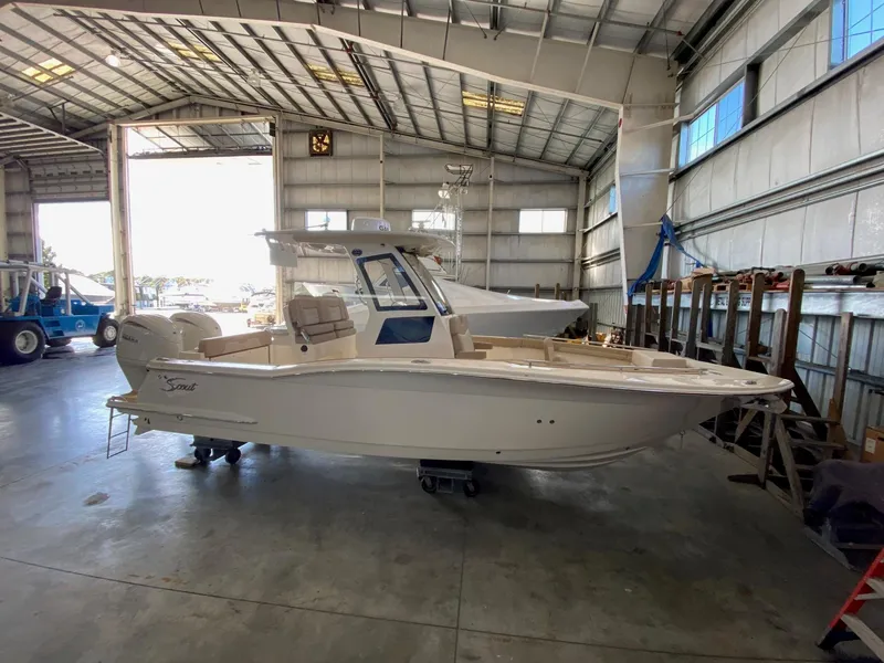 Slide: The Image of 2025 Scout 260 LXF boat in a spacious indoor marina. - 0