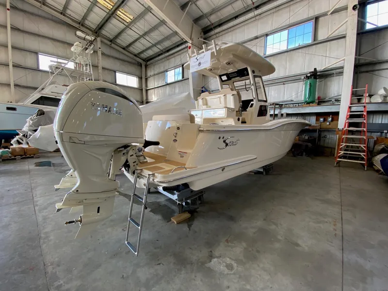 Slide: The Image of 2025 Scout 260 LXF boat in a warehouse, featuring powerful outboard motor. - 1