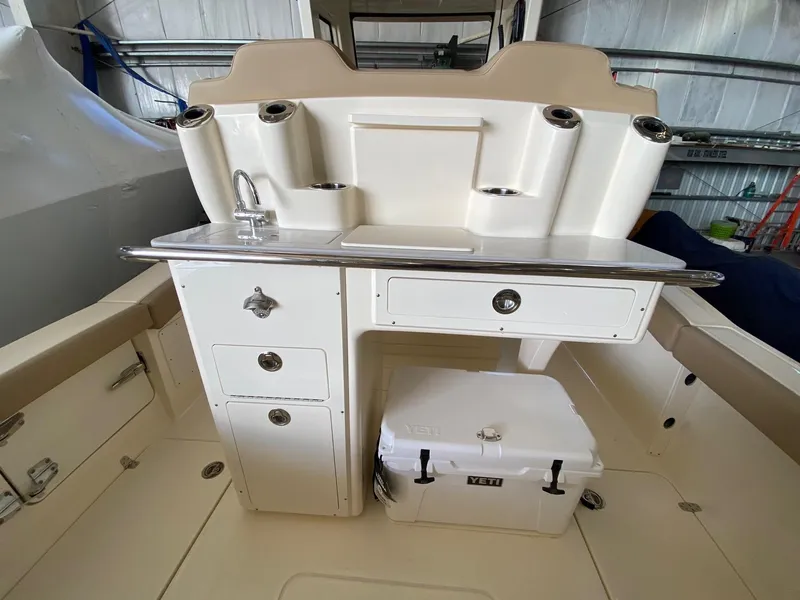 Slide: The Image of 2025 Scout 260 LXF boat interior with sink, storage, and Yeti cooler. - 10