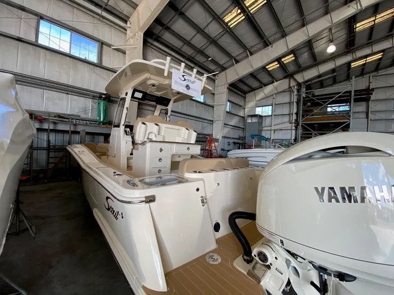 Slide: The Image of 2025 Scout 260 LXF boat with Yamaha engine in a storage facility. - 4