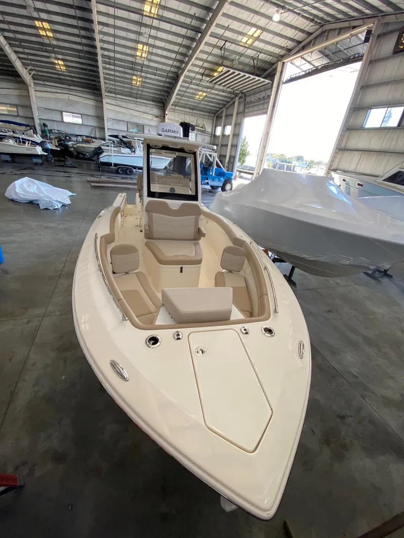 Slide: The Image of 2025 Scout 260 LXF boat in a spacious indoor showroom. - 6