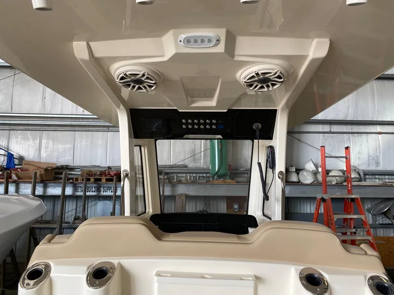 Slide: The Image of 2025 Scout 260 LXF boat interior with speakers and control panel in a warehouse. - 9
